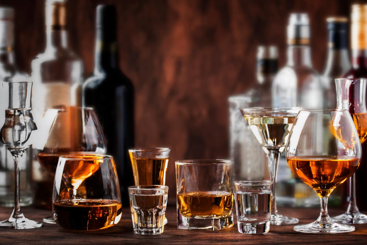Bar setting various alcoholic beverages in elegant glassware
